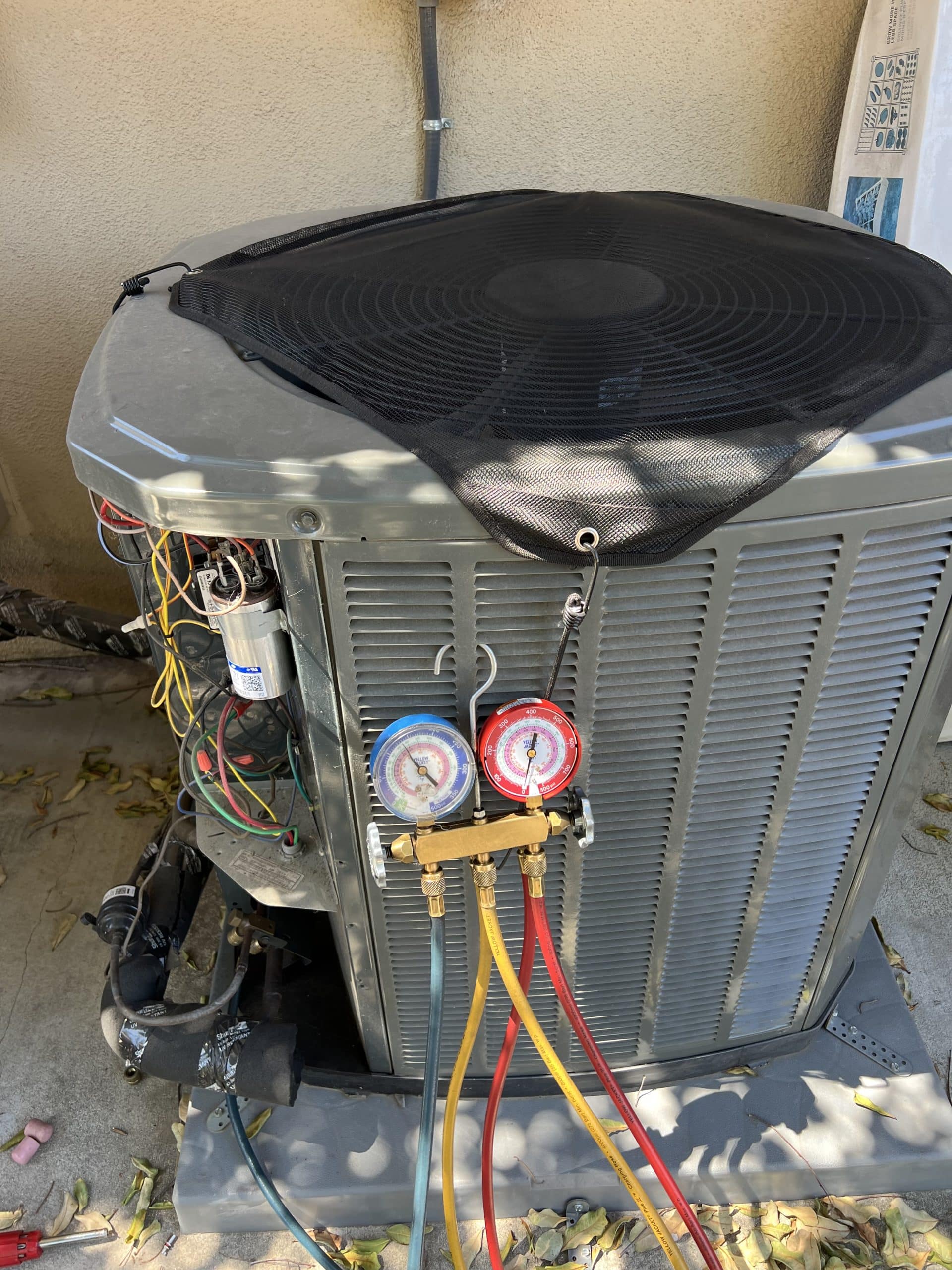 Air conditioning unit with connected gauges outdoors.