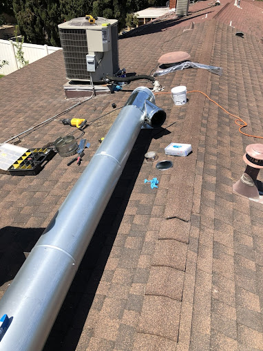 Roof with HVAC equipment and duct installation tools.