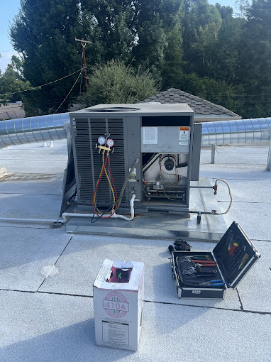 Rooftop HVAC unit maintenance tools and refrigerant.