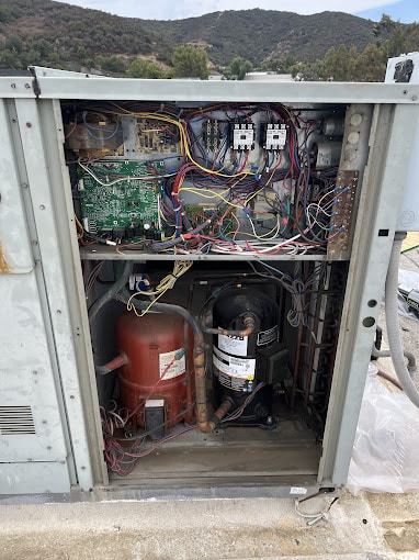 697897869 Open electrical cabinet with wires and components inside.