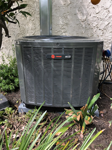 9090 Outdoor air conditioning unit in garden setting.
